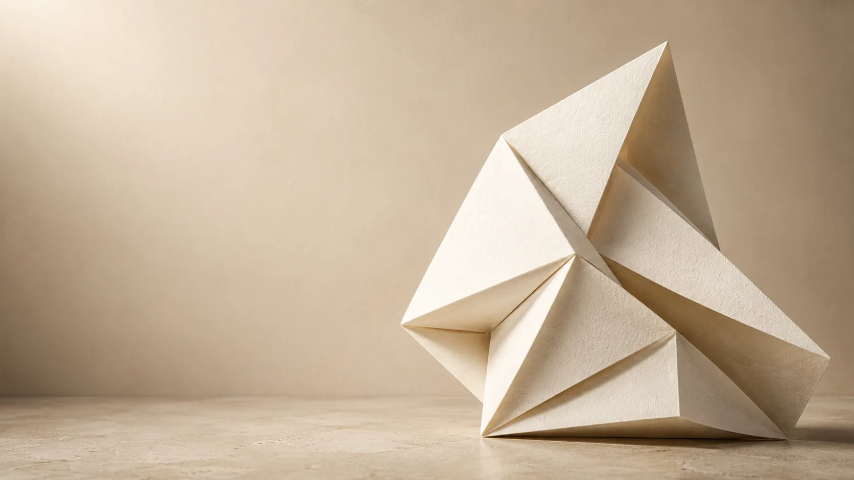 Sculptural origami-like folded paper form in warm ivory