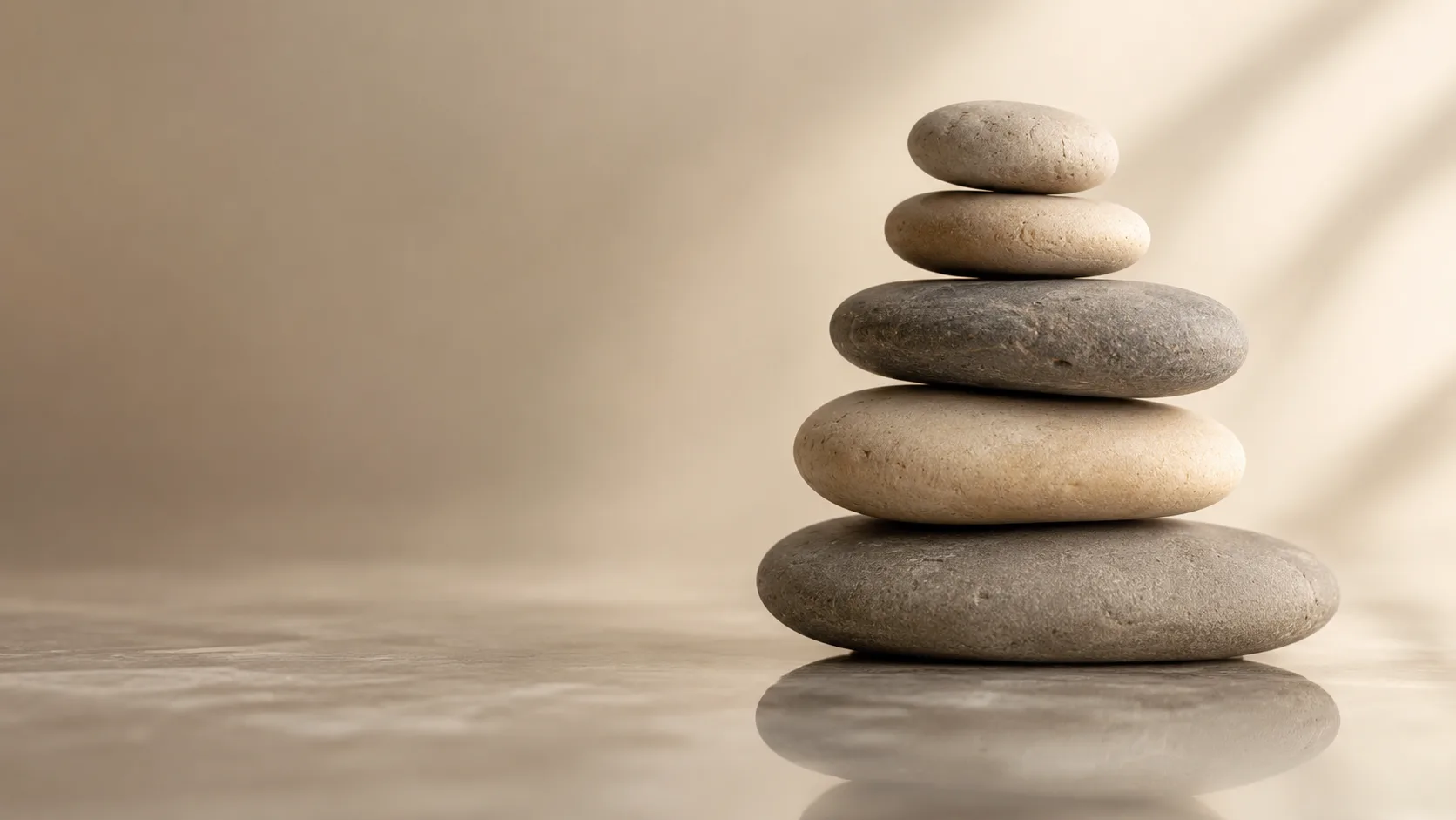 Stacked smooth river stones in soft warm light, wabi-sabi