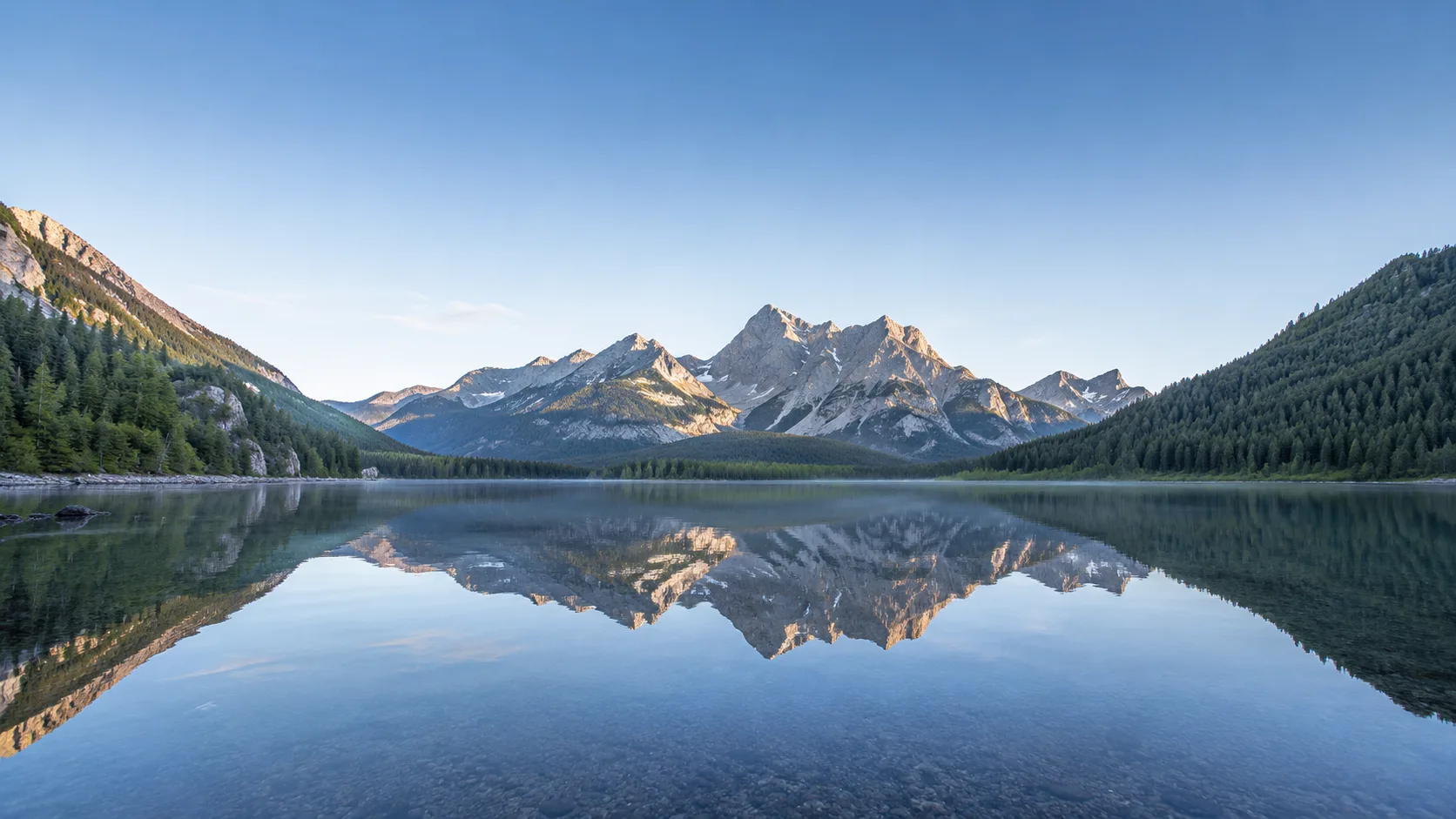Editorial landscape photograph of a calm mountain lake mirroring distant peaks