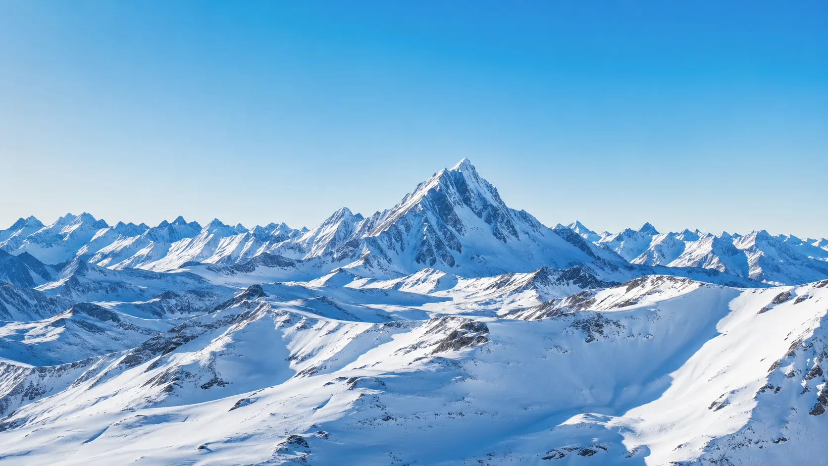 Editorial landscape photograph of snowy alpine peaks against a clear sky