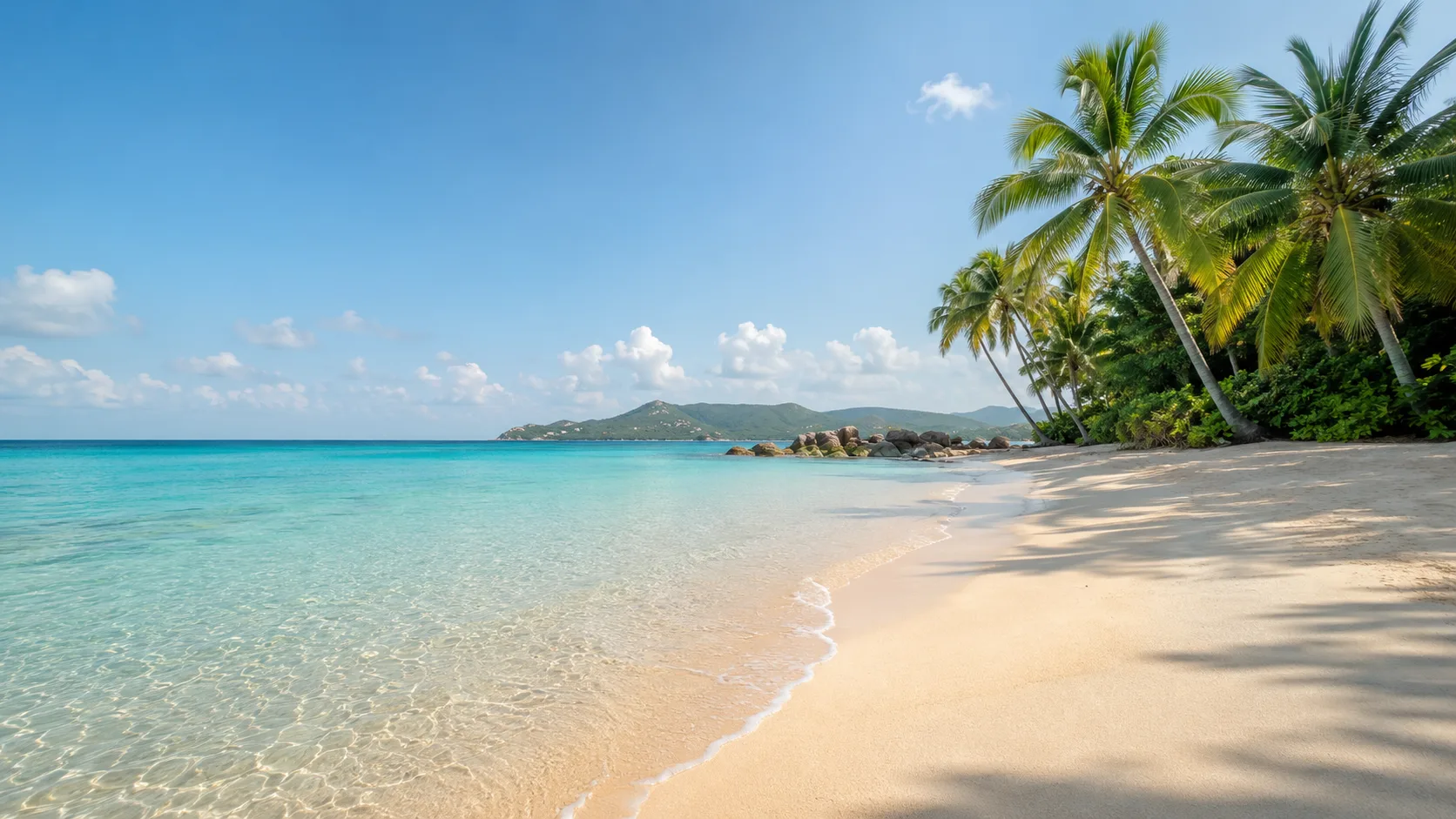 Editorial landscape photograph of a quiet tropical beach with pale sand and turquoise water