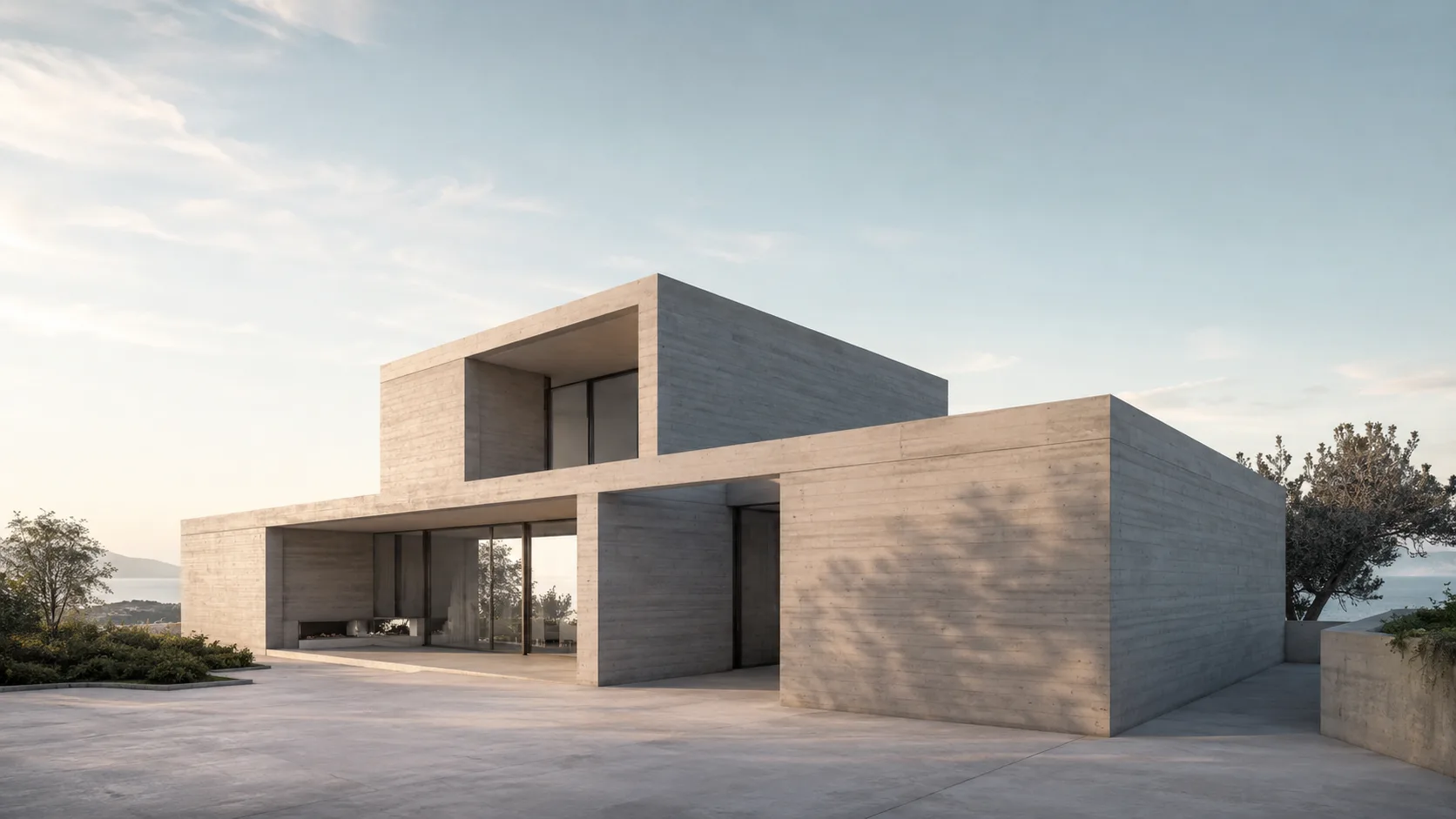 Editorial architecture photograph of a minimalist concrete house with clean geometric volumes