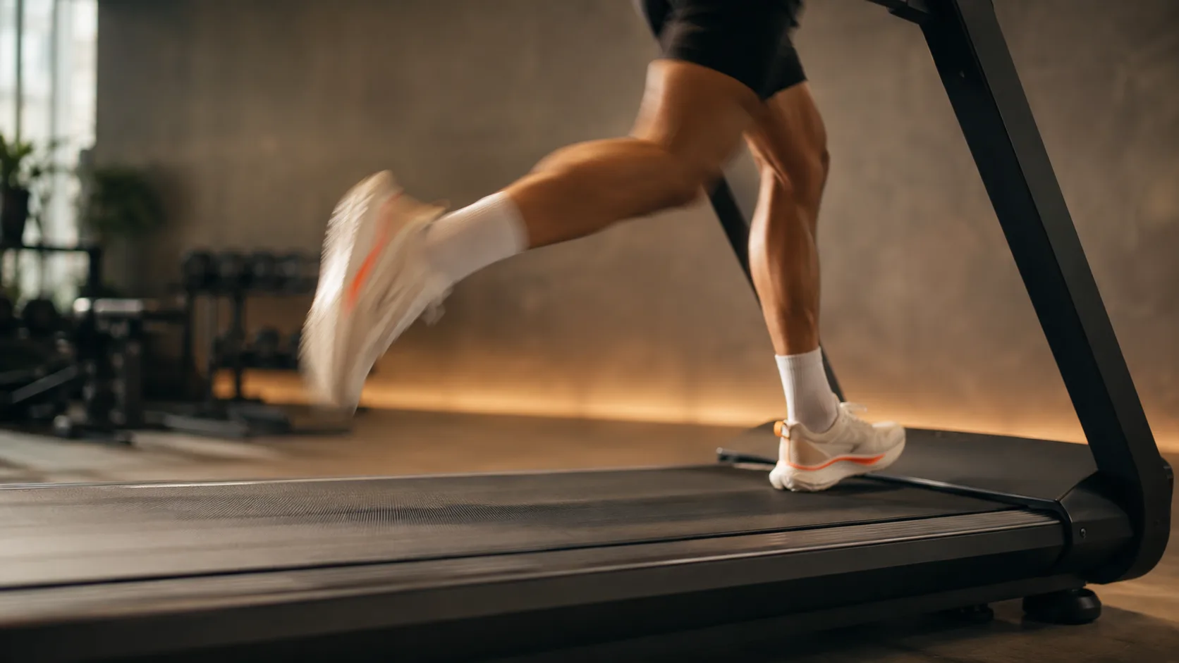 Fila de cintas de correr en una sala de gimnasio iluminada