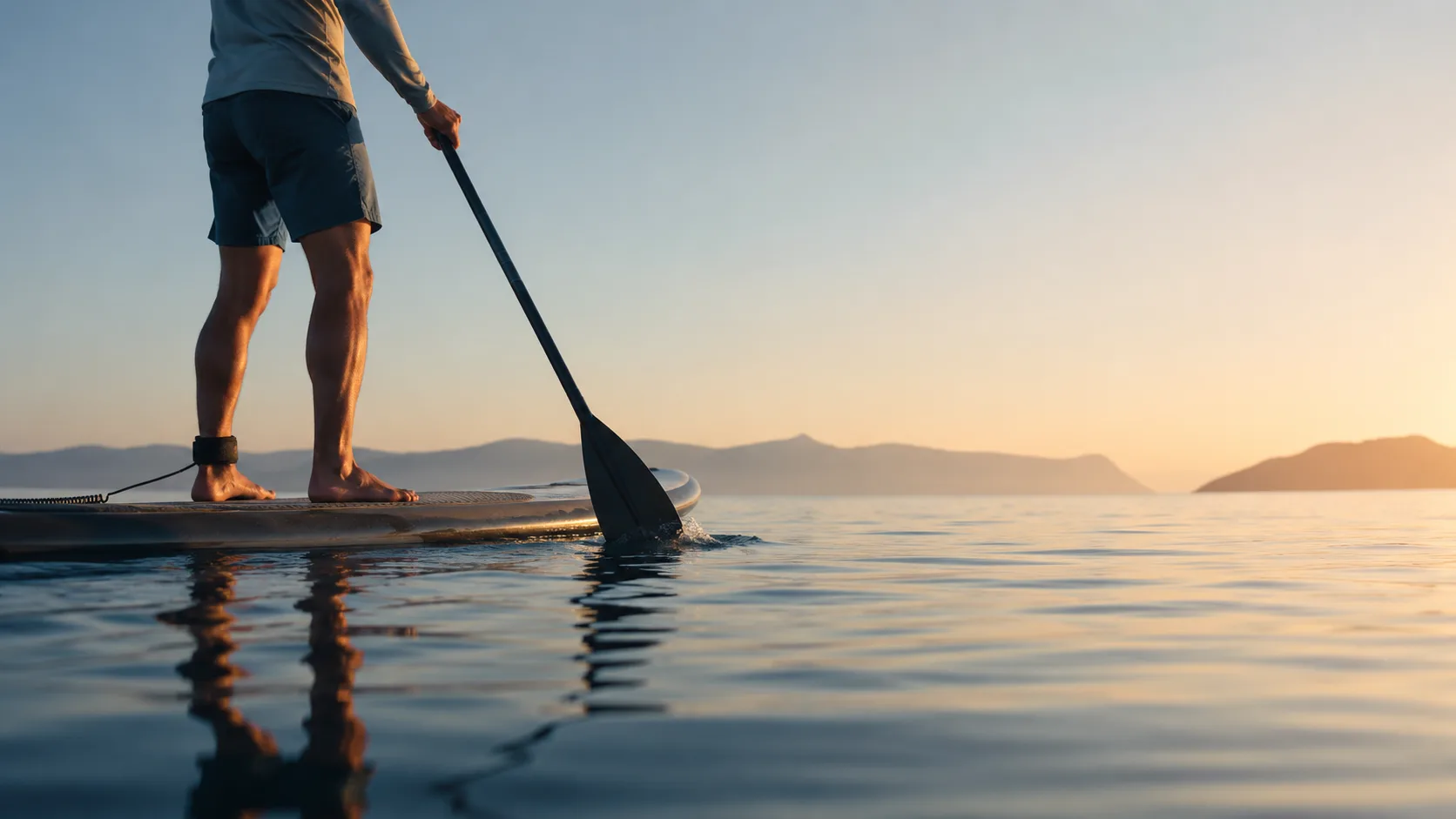 Paddleboard sobre agua en calma reflejando el cielo