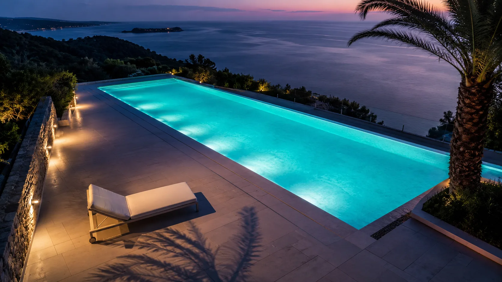 Piscina del hotel al anochecer con luces cálidas y montañas al fondo