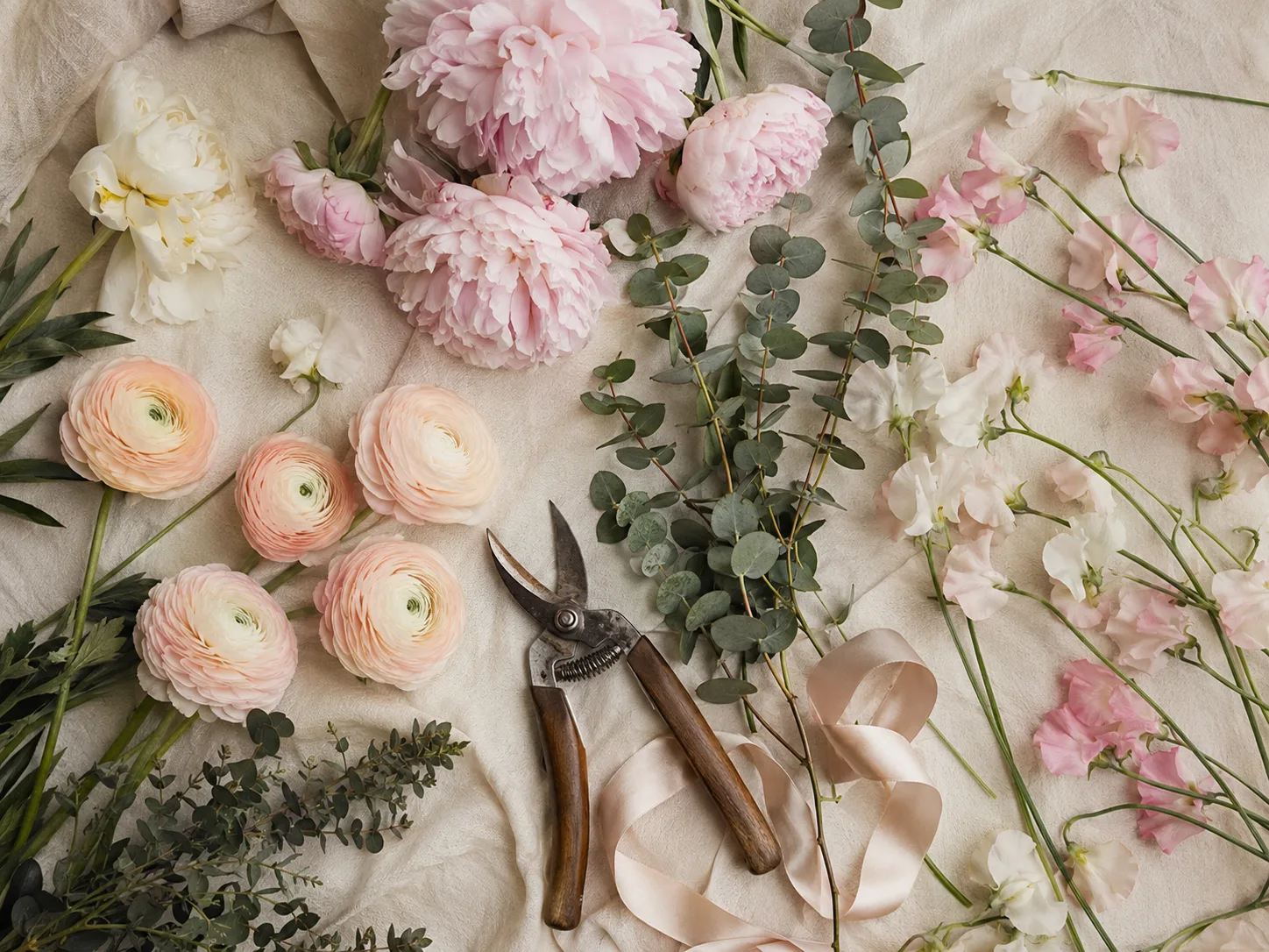 Composición floral en plano cenital con flores y follaje extendidos