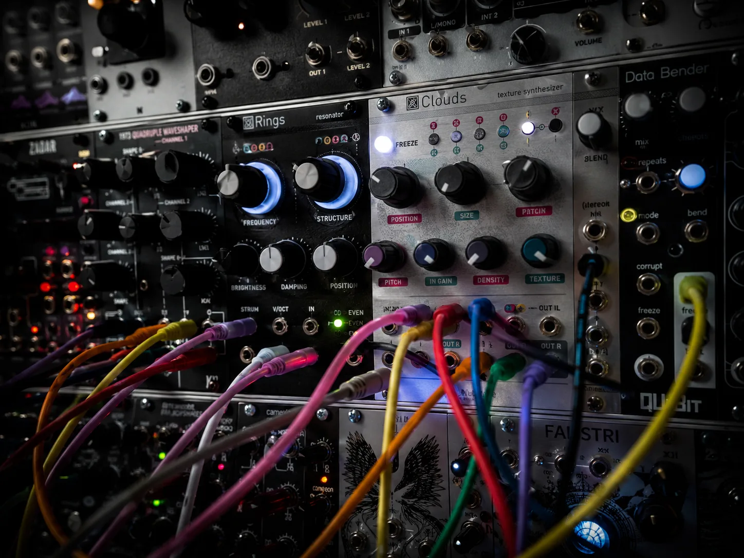 Editorial music macro of a Eurorack modular synth panel with rainbow patch cables crossing between modules