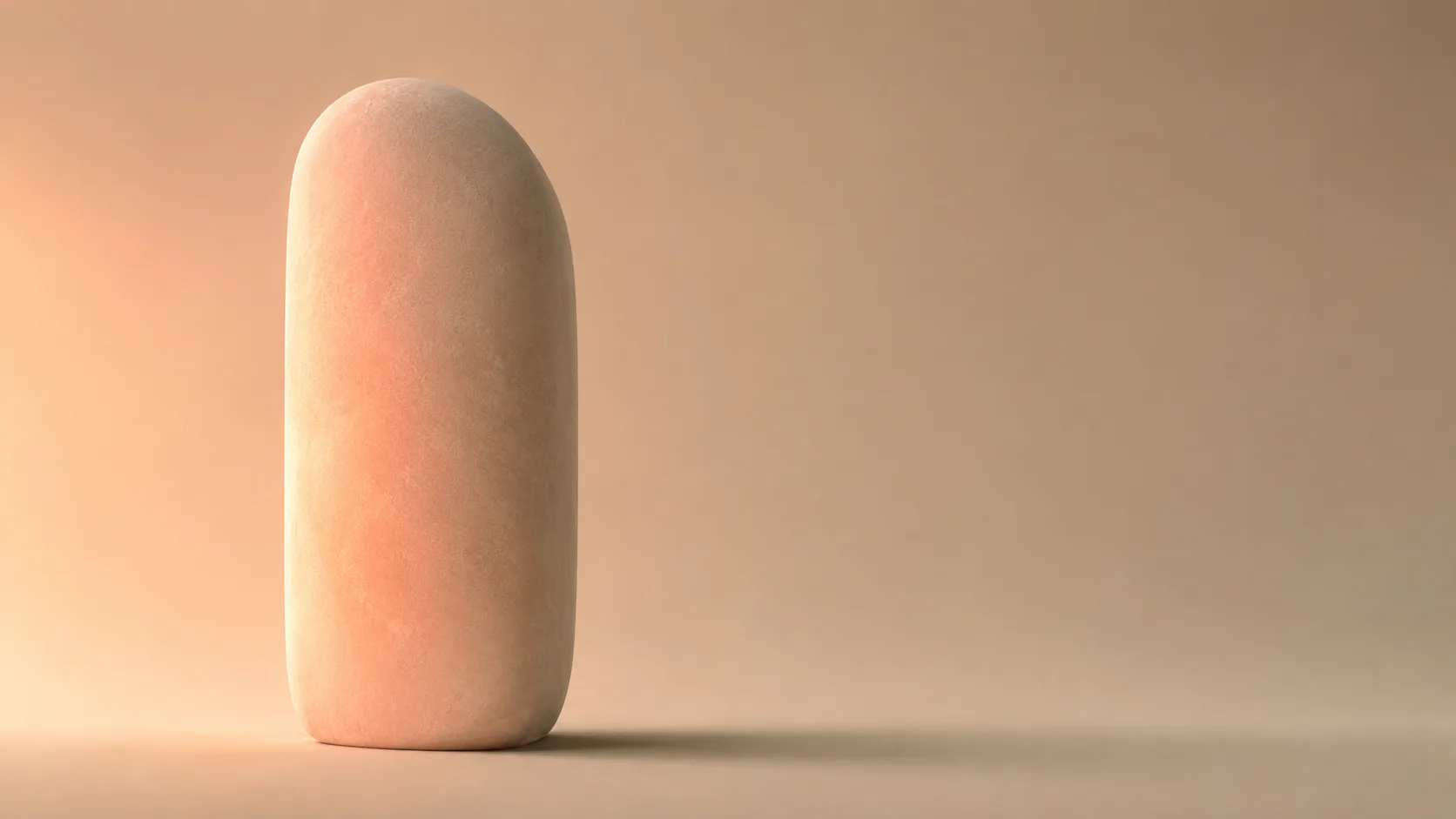 Single smooth rounded monolith grazed by a soft warm beam of light
